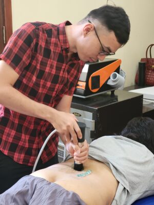Tác giả Lê Khắc Thuận điều trị đau lưng cho bệnh nhân bằng máy sóng xung kích